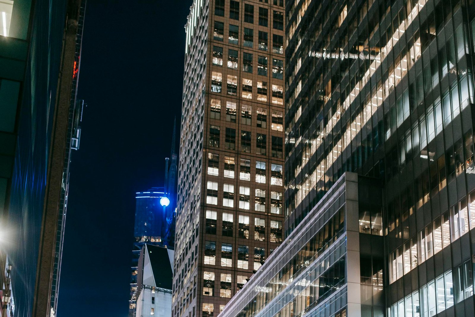 Modern skyscrapers with bright lights create a dramatic night scene in the city.